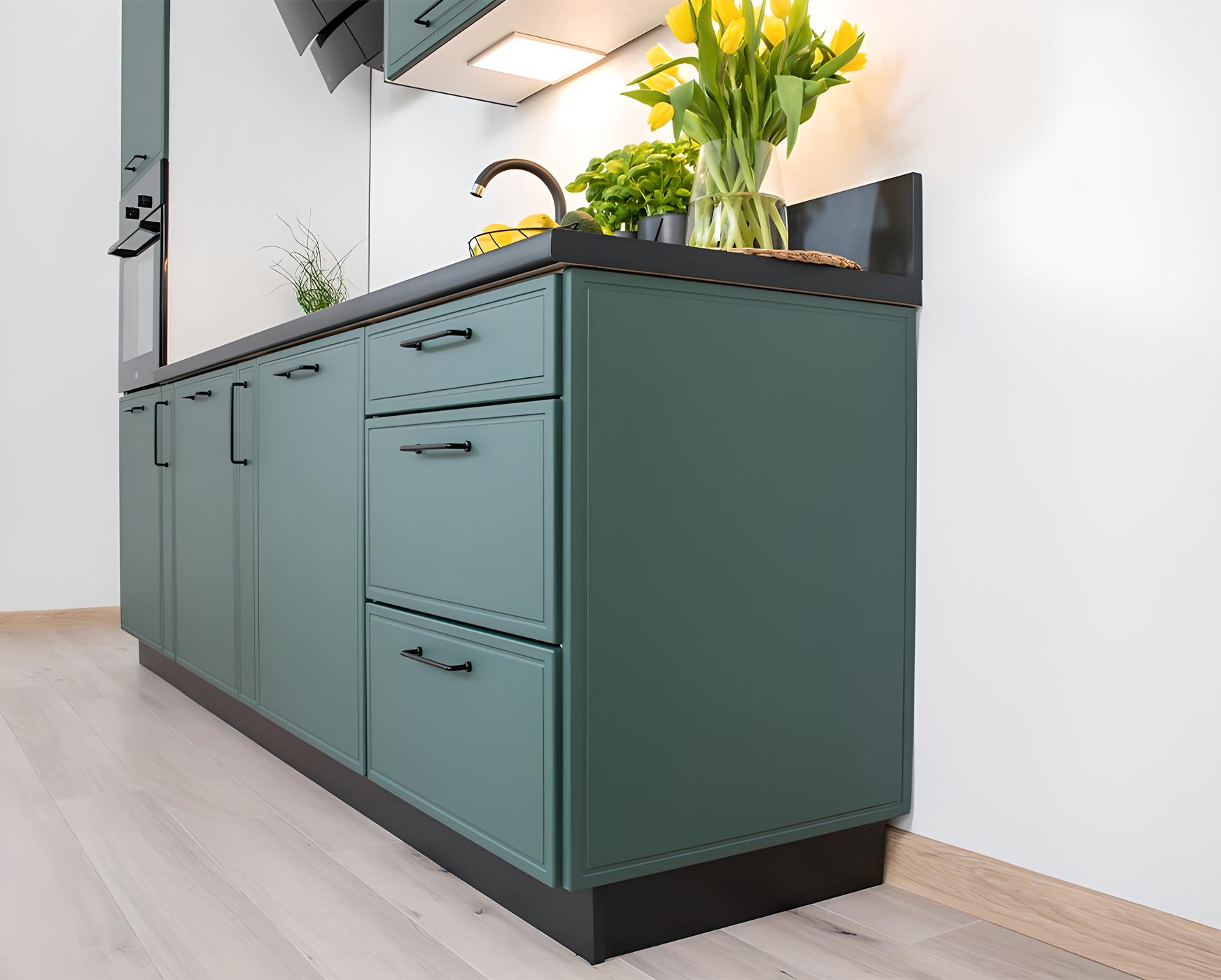 Les armoires vertes de la cuisine LYNN, accentuées par des poignées noires Les armoires vertes de la cuisine LYNN, accentuées par des poignées noires